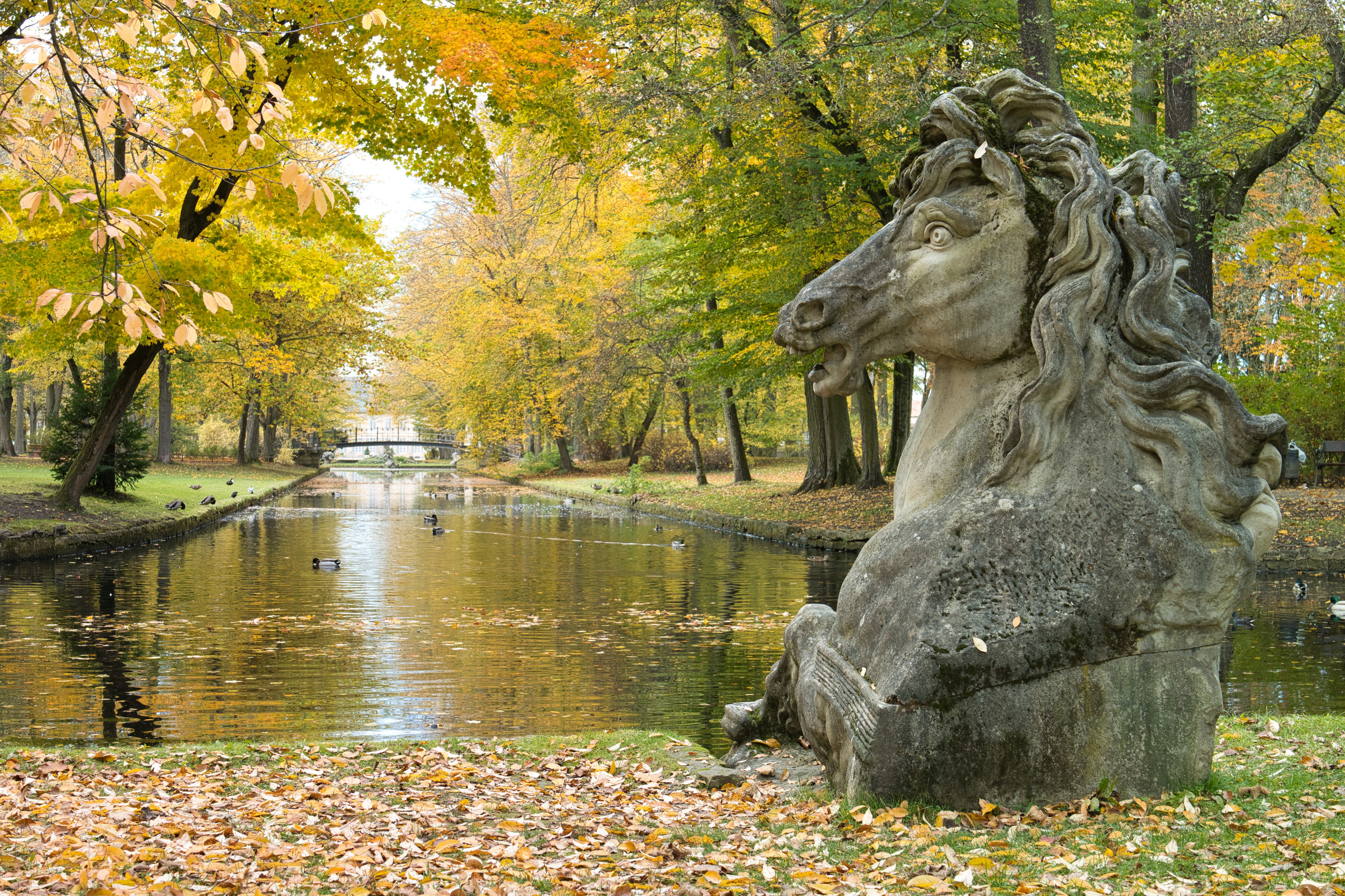 landscaped garden of the New Palace with a stone horse sculpture and water